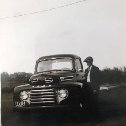 1949 ford pickup with grandpa standing beside it