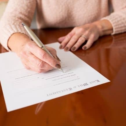 Woman signing her will - why you need a will and what happens when you don't have one