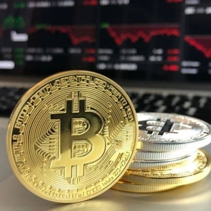 No, I'm Not Investing in Bitcoin - image of bitcoin with computer screen in background.
