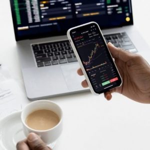 3 Ways to Start Investing in the Stock Market - hand holding phone showing stock prices