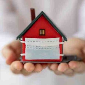House wearing a mask held in hands - the truth behind real estate investing in the second year of a pandemic.